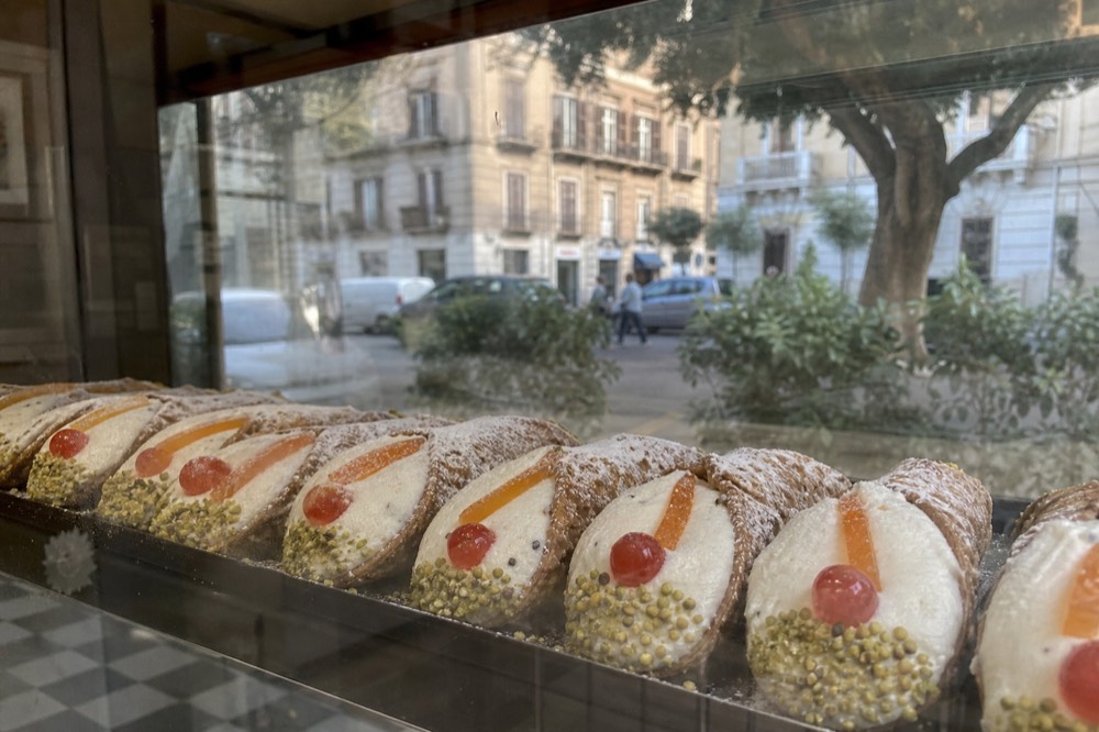 Cannoli filled with ricotta arranged in a pasticceria display case