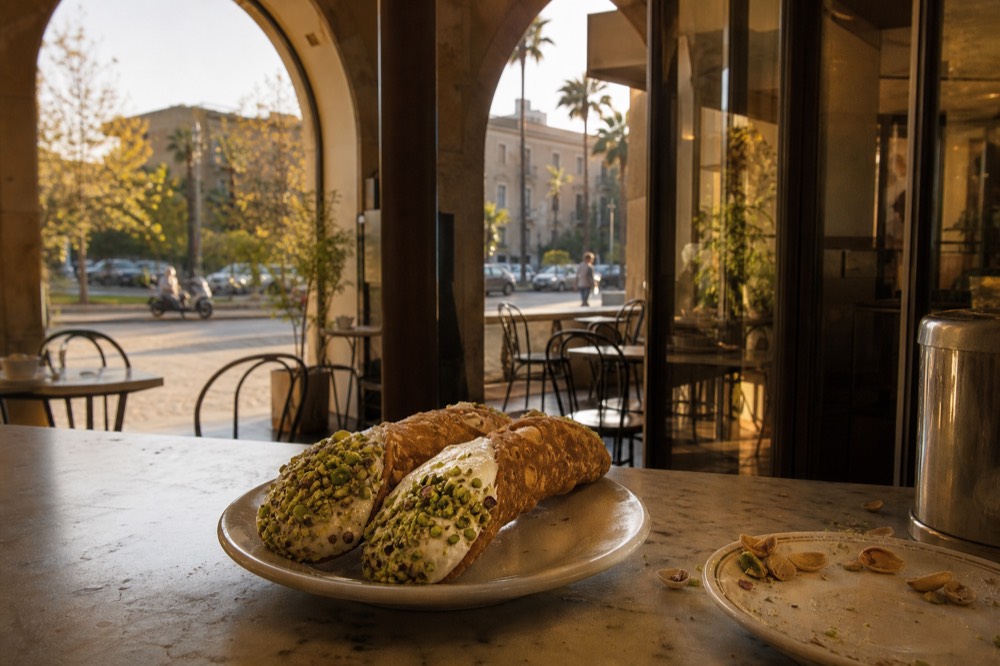 Sicilian cannoli filled with ricotta and pistachio on a café counter
