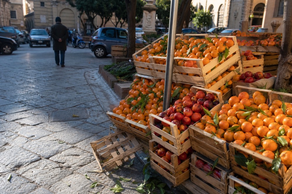 Fresh mandarins and blood oranges piled in wooden crates
