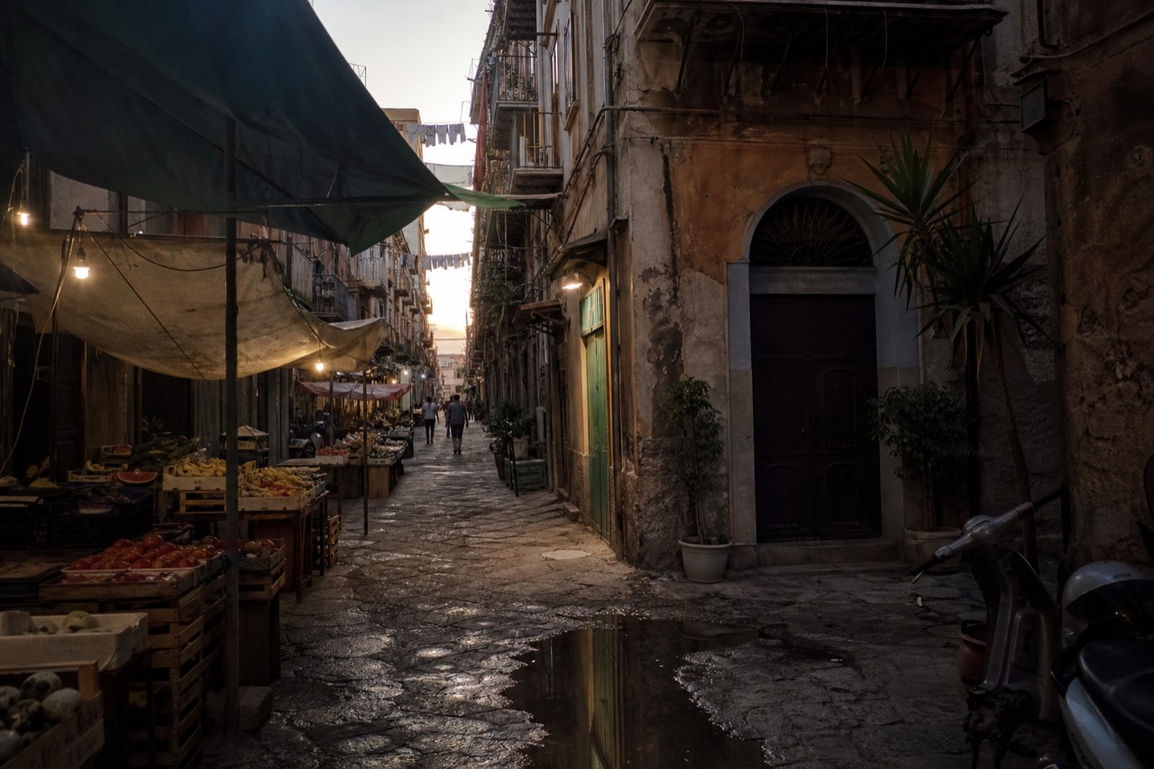 Narrow Palermo market lane lined with produce stalls under canvas awnings