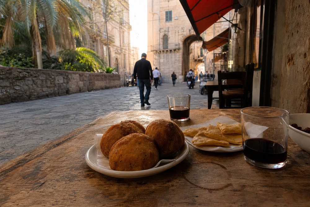 Table set with Sicilian street food tastings and glasses of wine