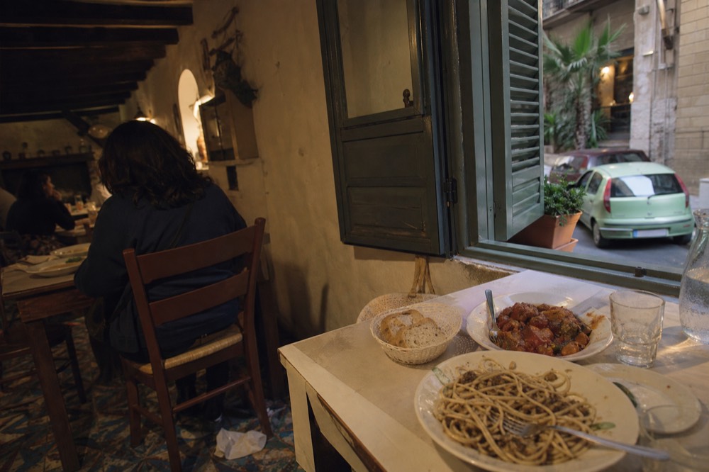 A table set with traditional Palermitan dishes at a trattoria