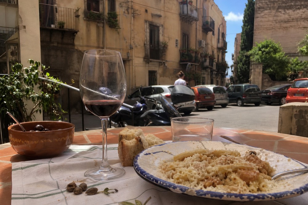 A Sicilian lunch of pasta, bread and wine on a tiled terrace table