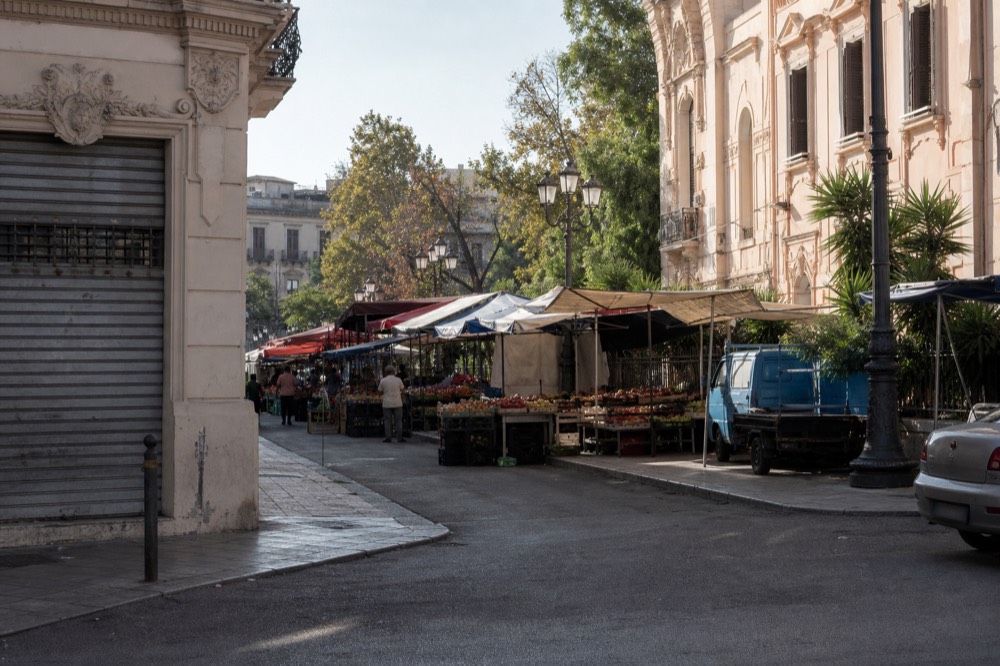 Morning market stalls on a street behind the Politeama theatre in Palermo
